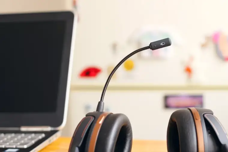Call centre headset resting beside a laptop on a desk