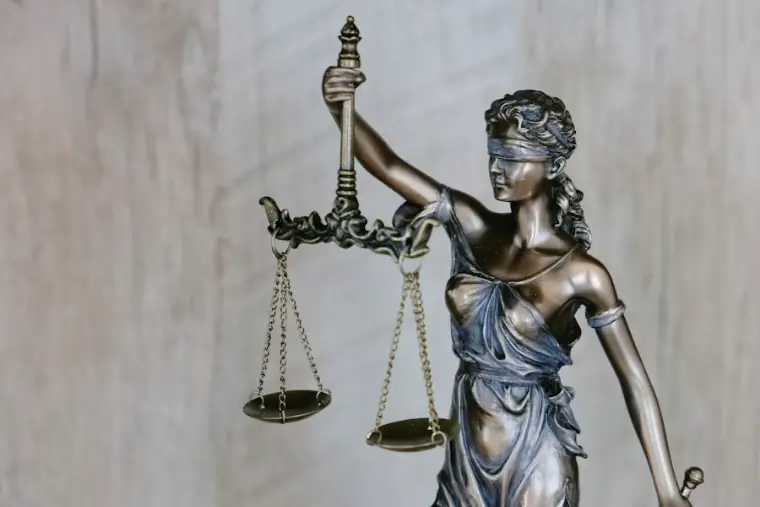 Bronze statue of Lady Justice holding balanced scales